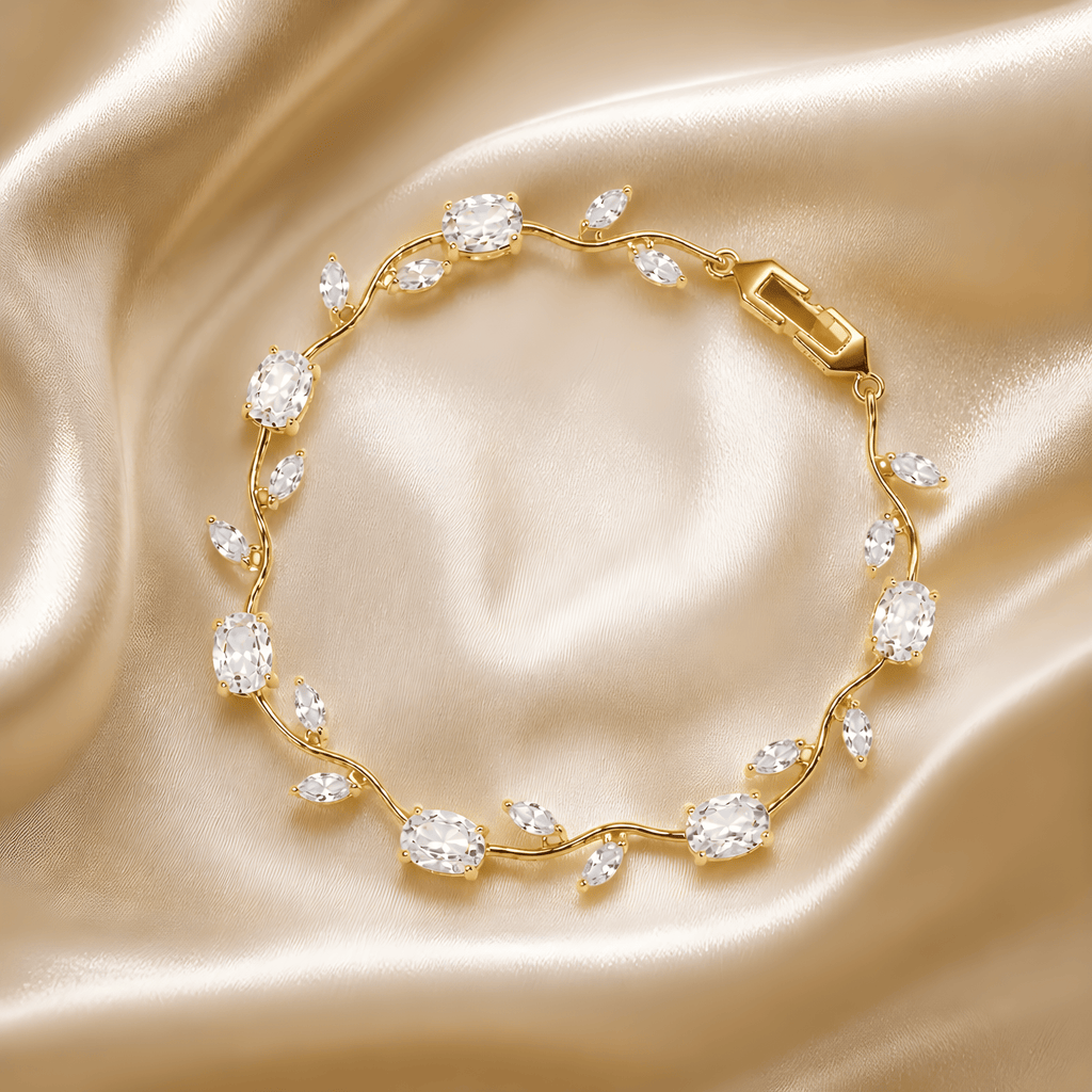 Tulipa White Armband mit 18K Goldvergoldung und weißen Zirkonia-Steinen auf champagnerfarbenem Seidensatin, Lifestyle-Aufnahme