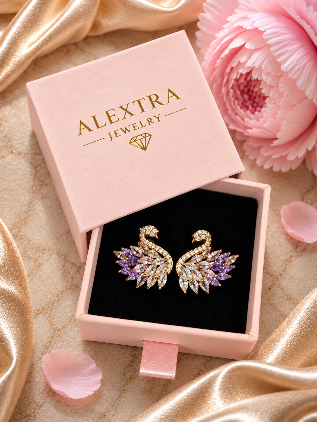 Amethystblüte Schwanohrringe in rosa Alextra Jewelry Geschenkbox auf schwarzem Einsatz, neben rosa Blüte und goldenem Satinstoff