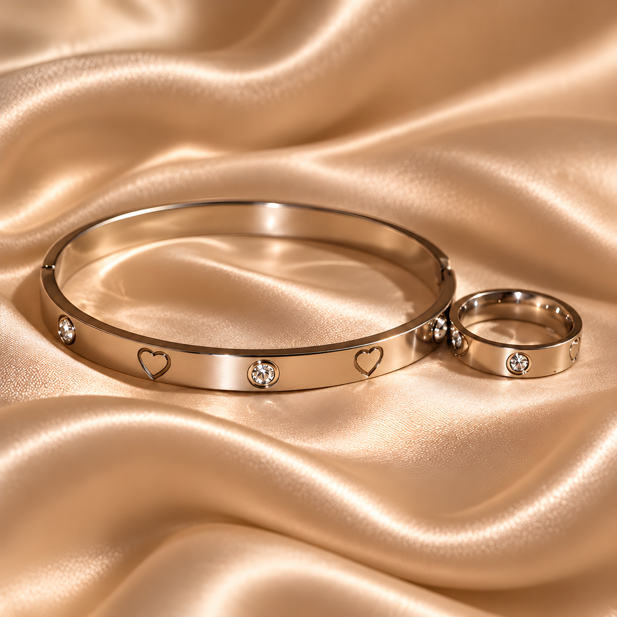 Juliette Armband und passender Ring mit Herzmotiven und Zirkonia auf champagnerfarbenem Satin