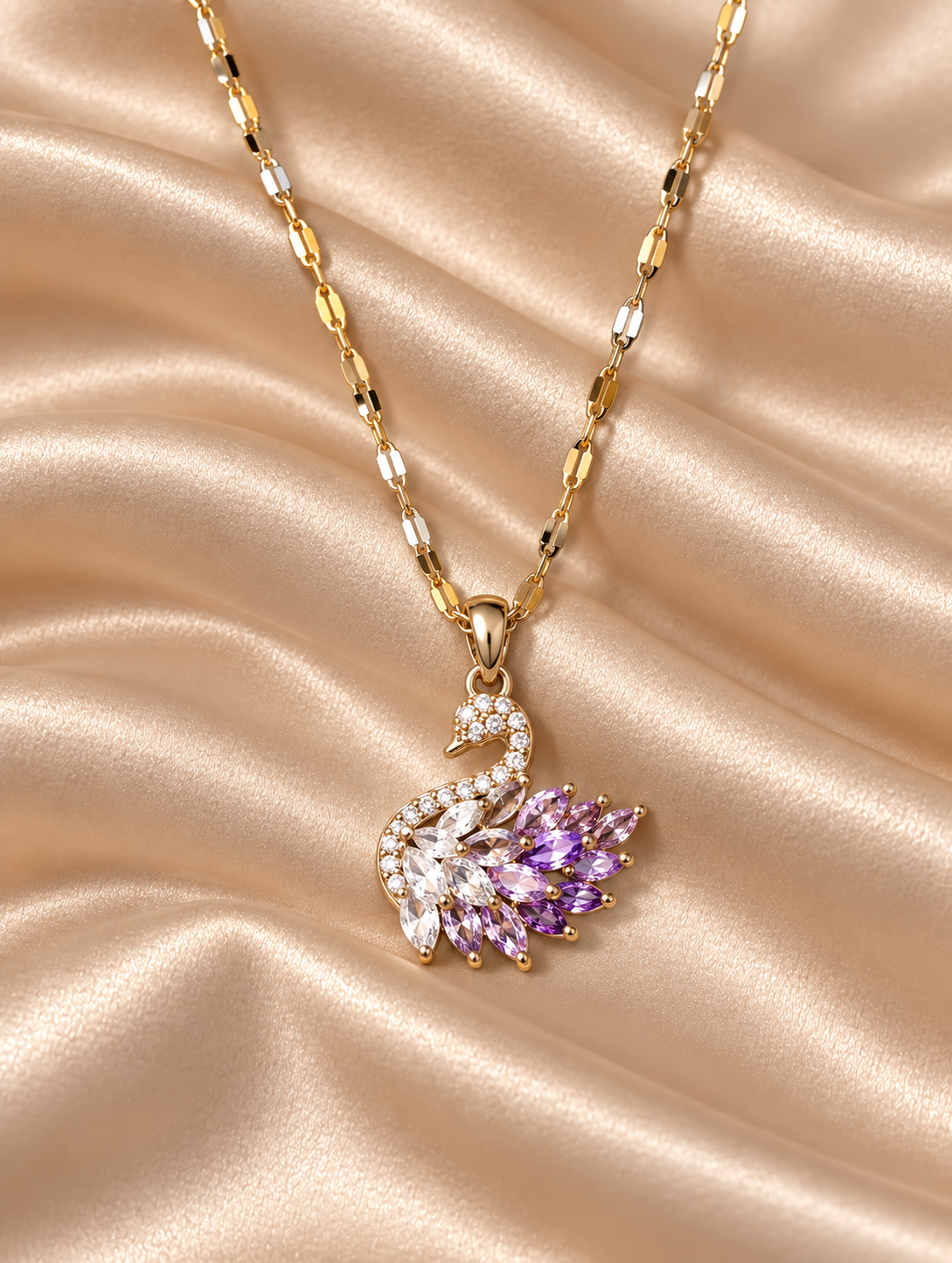 Goldfarbene Amethystblüte Schwan-Halskette mit Gliederkette und Schwan-Anhänger aus klaren und fliederfarbenen Zirkonia auf champagnerfarbenem Satin